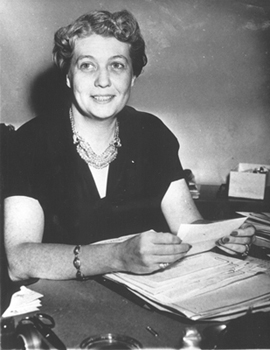 Photograph showing Grace Tully at work at her desk in the White House